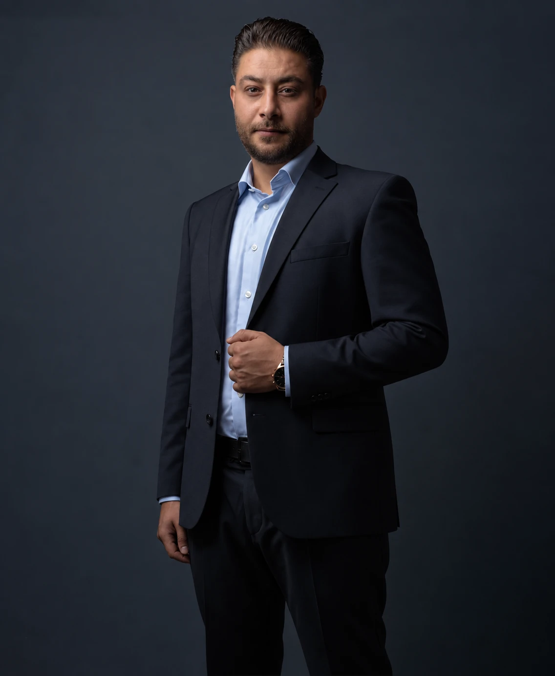Jamal Hajjo in dunklem Anzug, stehend vor ruhigem Hintergrund
